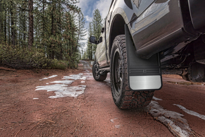 Universal 12in wide black rubber front mud flaps on a truck parked on a dirt road