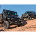 Jeep Wrangler JL 2.5in Stage 2 Suspension System with two jeeps parked on rocky hill