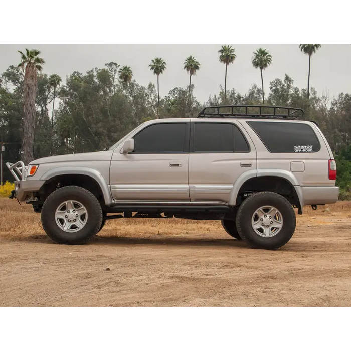 Silver toyota pickup truck parked in field with icon 96-02 toyota 4runner 0-3in stage 3 suspension system.