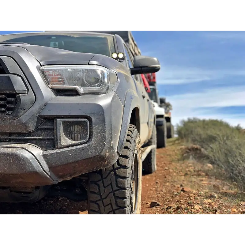 Toyota Tacoma driving down dirt road with LED fog beam.