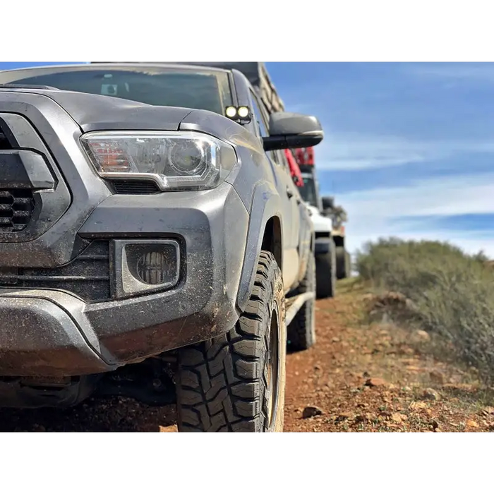 Toyota Tacoma driving down dirt road with LED fog beam.