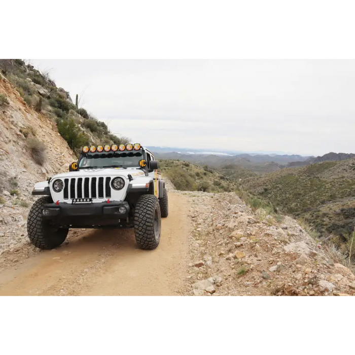 Jeep driving down dirt road with round soft vinyl light covers