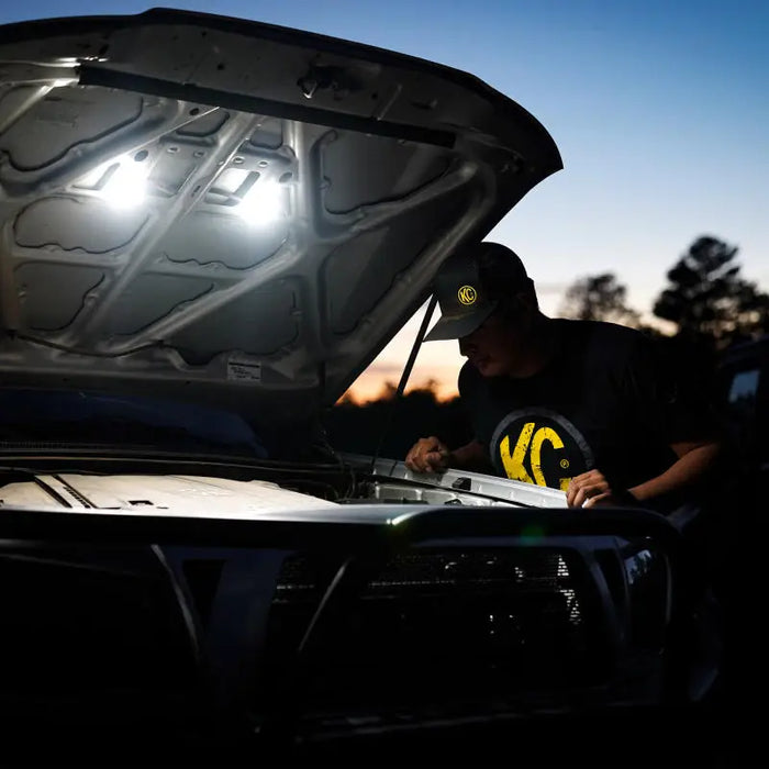 Mechanic working on car under hood with KC HiLiTES Cyclone 2in. LED Universal Under Hood Lighting Kit