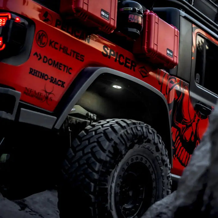 Red jeep with black and red decal featuring KC HiLiTES Cyclone V2 LED flood beam light