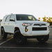 White Toyota SUV parked in parking lot with KC HiLiTES FLEX ERA 3 Dual Mode SAE Fog Lights.