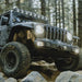 Jeep driving through rocks with KC HiLiTES FLEX ERA 3 Dual Mode SAE Fog Lights - 2-Light Master Kit