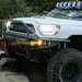 White truck driving on rocky trail, KC HiLiTES FLEX ERA 3 Dual Mode SAE Fog Lights.