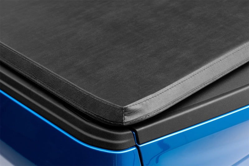 Lund genesis tri-fold tonneau cover on blue car with black seat pad