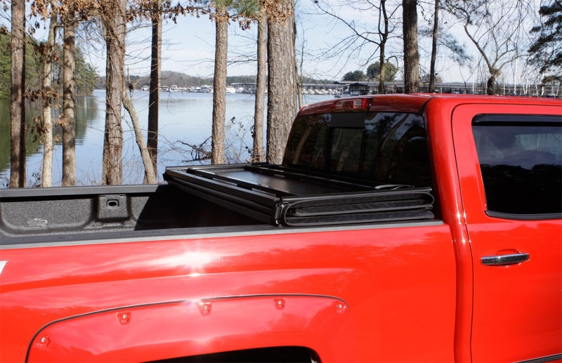 Red truck parked in front of lake - lund 05-15 toyota tacoma fleetside hard fold tonneau cover
