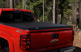 Red truck parked in driveway featuring lund hard fold tonneau cover