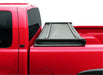 Black lund genesis tri-fold tonneau cover on a red truck with bed cover