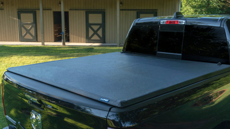 Black lund genesis tri-fold tonneau cover on toyota tacoma truck bed