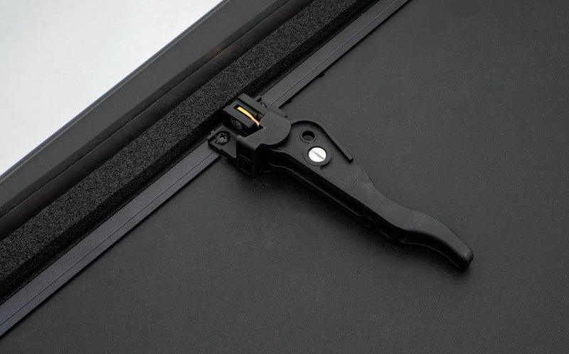 Black metal frame with handle on lund 16-23 toyota tacoma hard fold tonneau cover
