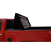 Red truck with open door next to lund hard fold tonneau cover for toyota tacoma