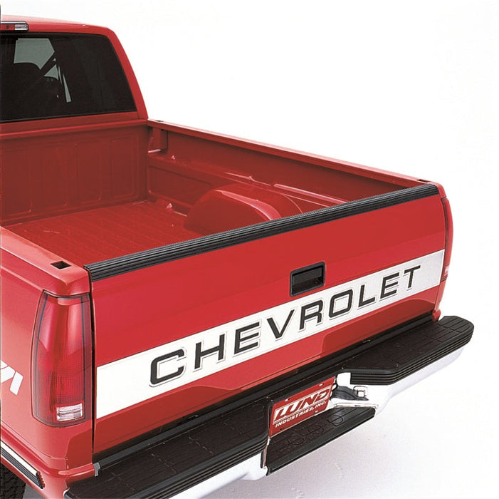 Red truck with black stripe on bed, displayed with lund universal tailgate protector - black