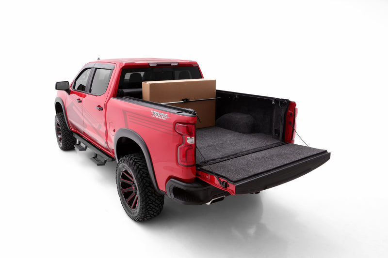 Red truck with cargo box: lund universal ratcheting cargo bar in black