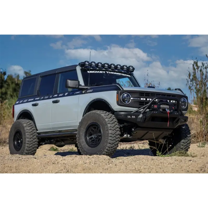 Front end view of white truck with black bumper featuring Mickey Thompson Baja Legend MTZ Tire.