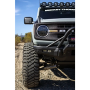 Close-up image of a truck with a light on and a bumper mounted, showcasing the Mickey Thompson Baja Legend MTZ Tire.