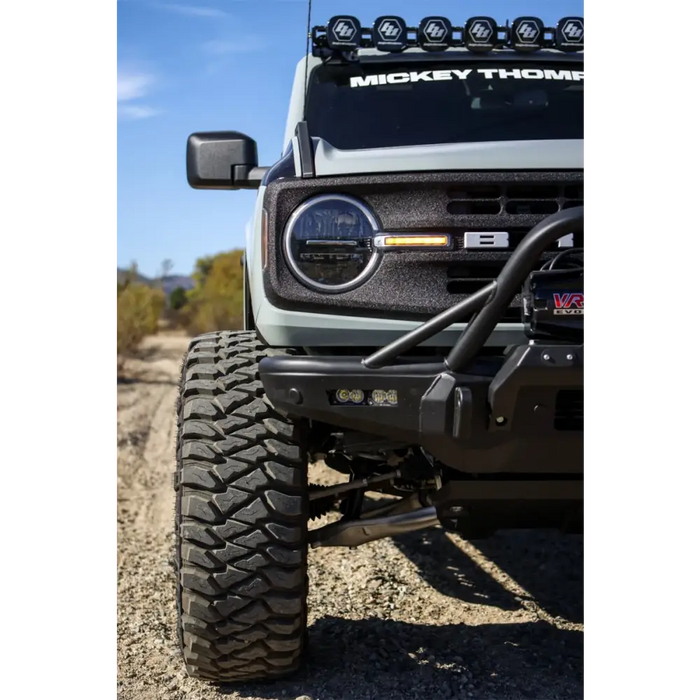 Close-up image of a truck with a light on and a bumper mounted, showcasing the Mickey Thompson Baja Legend MTZ Tire.