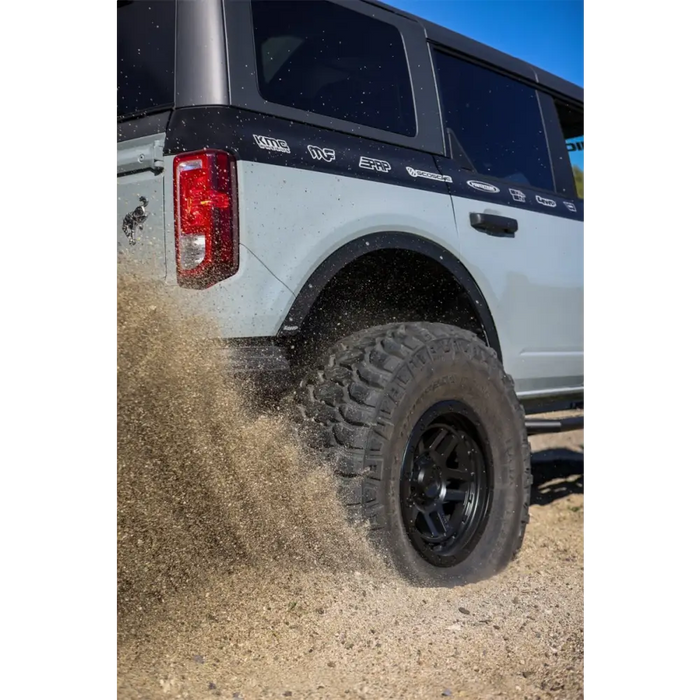 White truck driving through muddy road, showcasing Mickey Thompson Baja Legend MTZ tire.