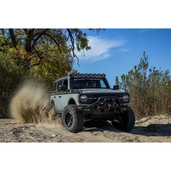 Jeep driving through muddy Baja Legend MTZ trail.