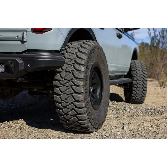 Front end of silver truck with large tire - Mickey Thompson Baja Legend MTZ Tire.