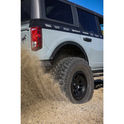 White truck driving through muddy road with Mickey Thompson Baja Legend MTZ tire.