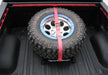 N-fab bed mounted tire carrier with gloss black finish and red strap