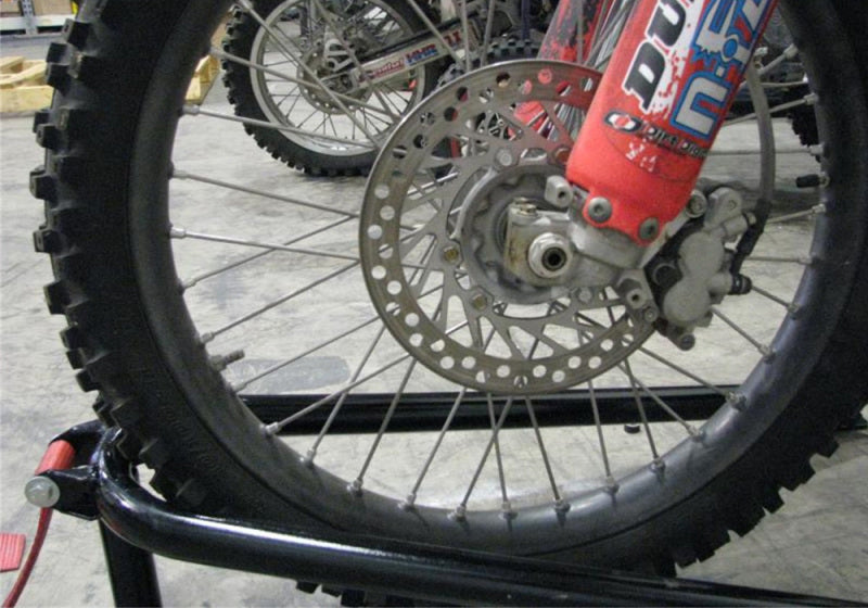 Mechanic working on bed mounted tire carrier on motorcycle