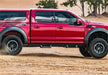 Red toyota tacoma double cab truck driving through dirt field