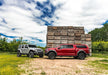 Red toyota tacoma double cab trucks parked in front of wooden cabin