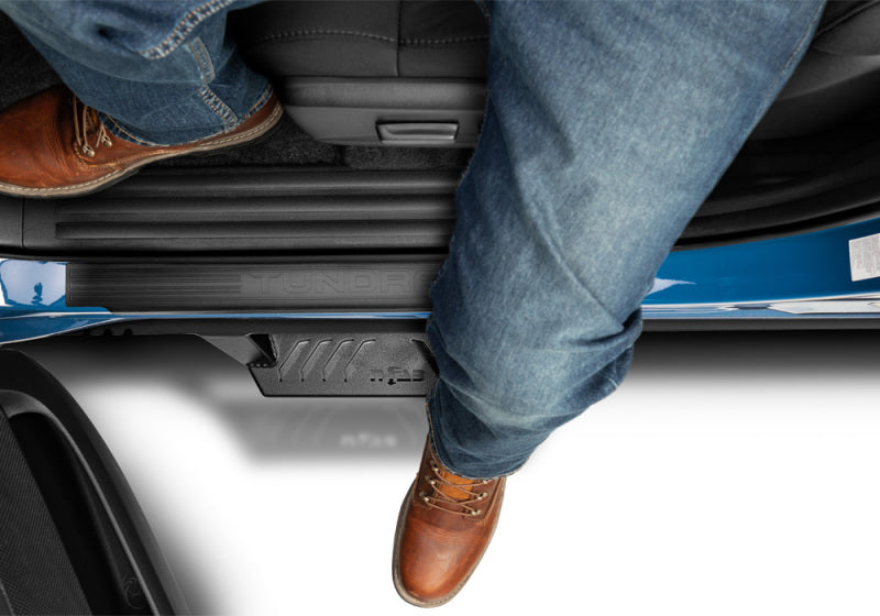 Person sitting on back of toyota tacoma double cab in n-fab epyx cab length side steps