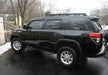 Black toyota 4 runner suv with n-fab wheel nerf steps parked in a lot