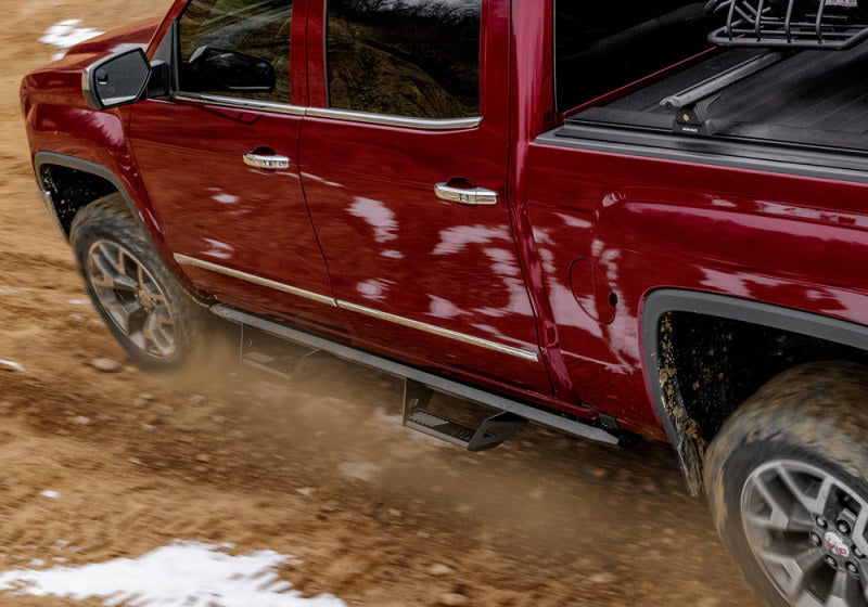 Red truck driving down dirt road - n-fab predator pro step system for toyota tacoma double cab