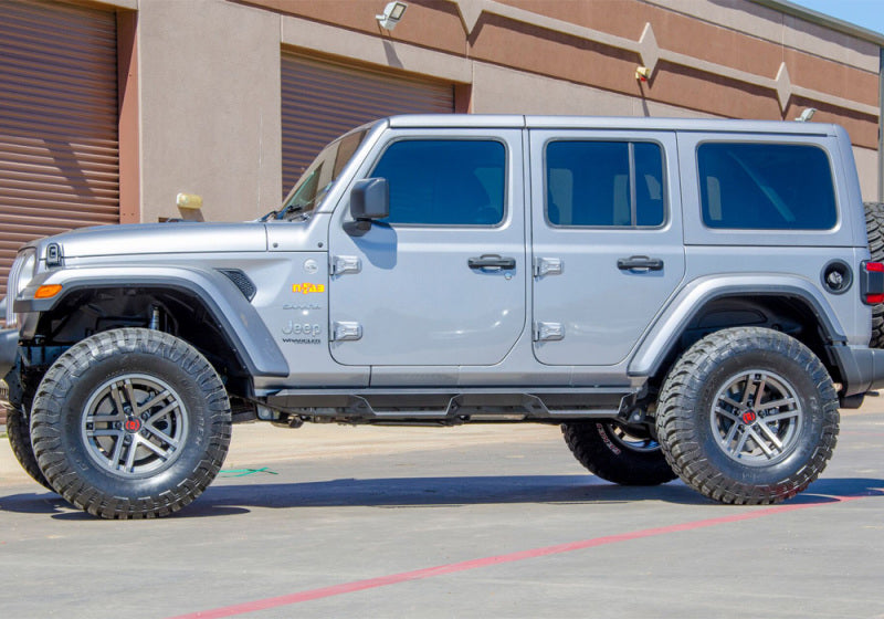 N-fab predator pro step system on silver jeep parked in front of building