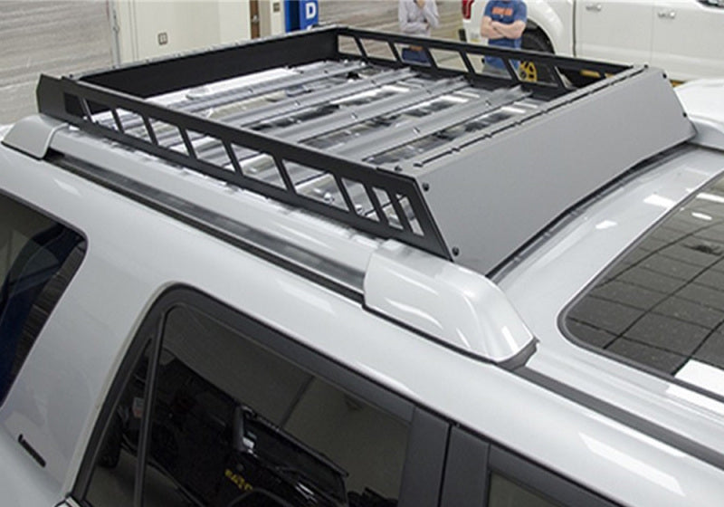 Man working on car with n-fab roof rack 10-17 toyota 4 runner in a garage