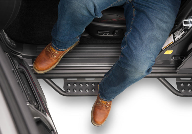 Man with jeans and brown shoes sitting in back of car - n-fab rs nerf step 10-19 toyota 4runner - cab length nerf steps