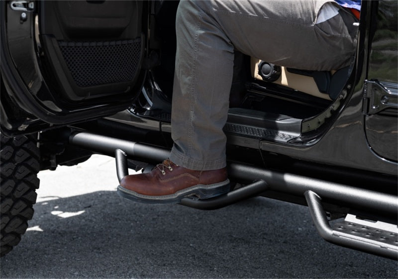 Man sitting in the back of a truck with n-fab rs nerf steps for jeep wrangler jl 4dr
