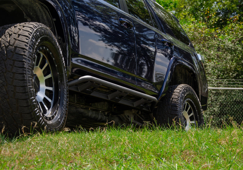 Black jeep parked on grass - n-fab trail slider steps for toyota 4runner in textured black