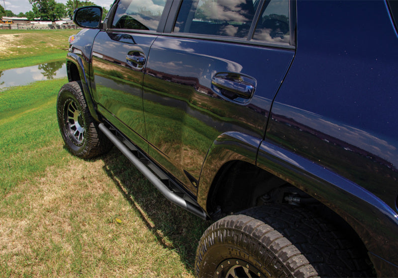 Black truck parked in field beside n-fab trail slider steps for 10-20 toyota 4runner