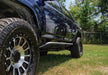 N-fab trail slider steps in textured black on truck parked in grass