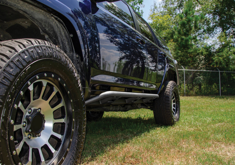 N-fab trail slider steps in textured black on truck parked in grass