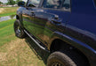 N-fab trail slider steps in textured black on a black truck parked in a field