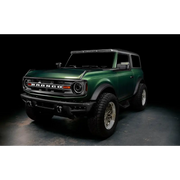 Green lifted truck with black bumper featuring Oracle’s 2021+ Ford Bronco Integrated Windshield Roof LED Light Bar System.