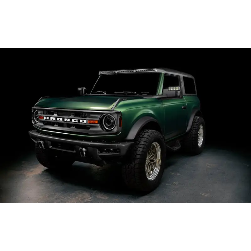 Green lifted truck with black bumper featuring Oracle’s 2021+ Ford Bronco Integrated Windshield Roof LED Light Bar System.