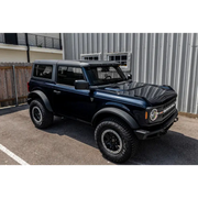 Black jeep with roof rack featuring Oracle 2021+ Ford Bronco Integrated Windshield Roof LED Light Bar System