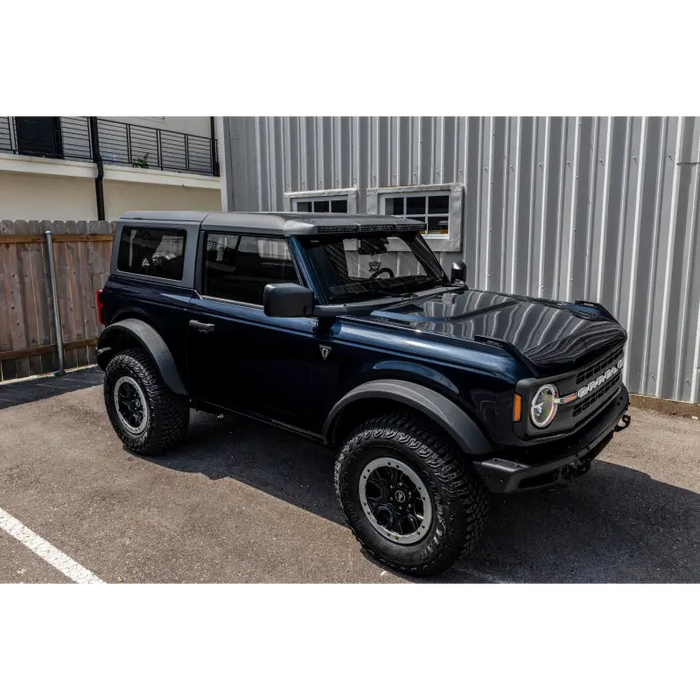 Black jeep with roof rack featuring Oracle 2021+ Ford Bronco Integrated Windshield Roof LED Light Bar System