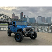 Dynamic blue jeep with oversized tire, featuring Oracle 7in High Powered LED Headlights.