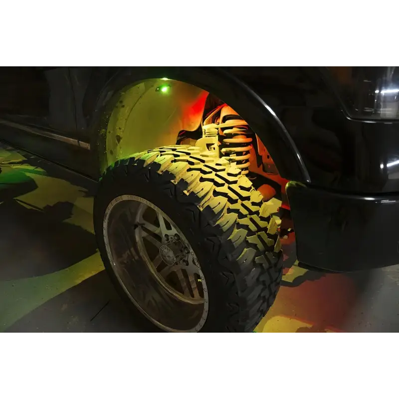 Black truck with yellow tire cover, part of Oracle Bluetooth + RF Underbody Rock Light Kit - 8 PCS - ColorSHIFT.