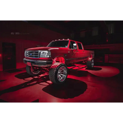 Red truck parked in garage with Oracle Bluetooth + RF Underbody Rock Light Kit - 8 PCS - ColorSHIFT.
